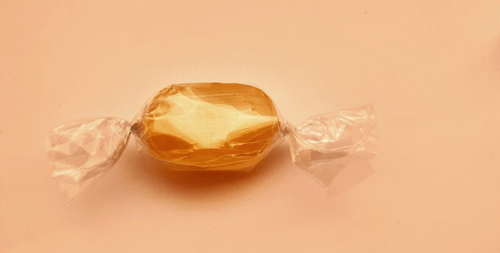 A round golden-yellow Coin Volcano mango candy